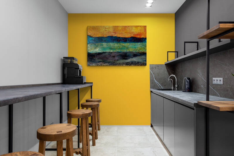 3. Beispielbild für Wirkung im Raum von farbintensiven Acrylgemälden: Bar mit gelber Wand. An der gelben Wand hängt das Kunstwerk mit den 4 horizontalen Farbflächen. 